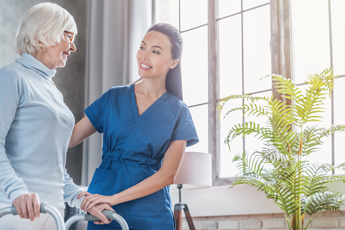 senior female using a walker with caregiver