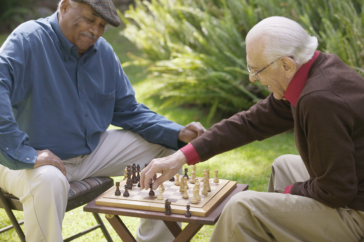 older adult males playing chess