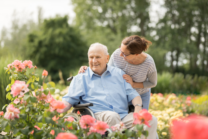 older adult male with adult daughter outside in garden